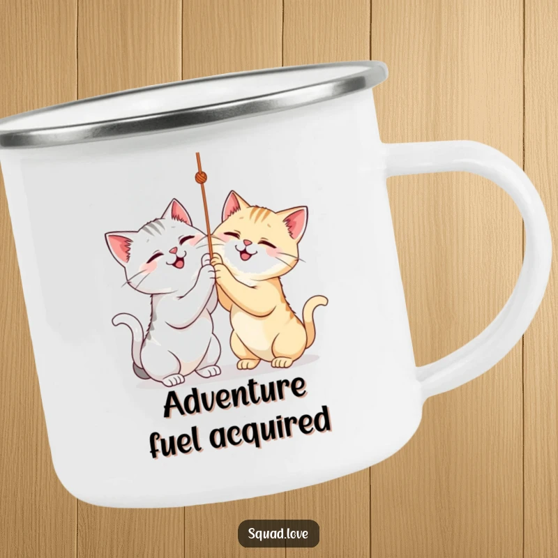 Funny camping mug depicting two cats playfully batting at a string, ideal for outdoor fun and warmth.